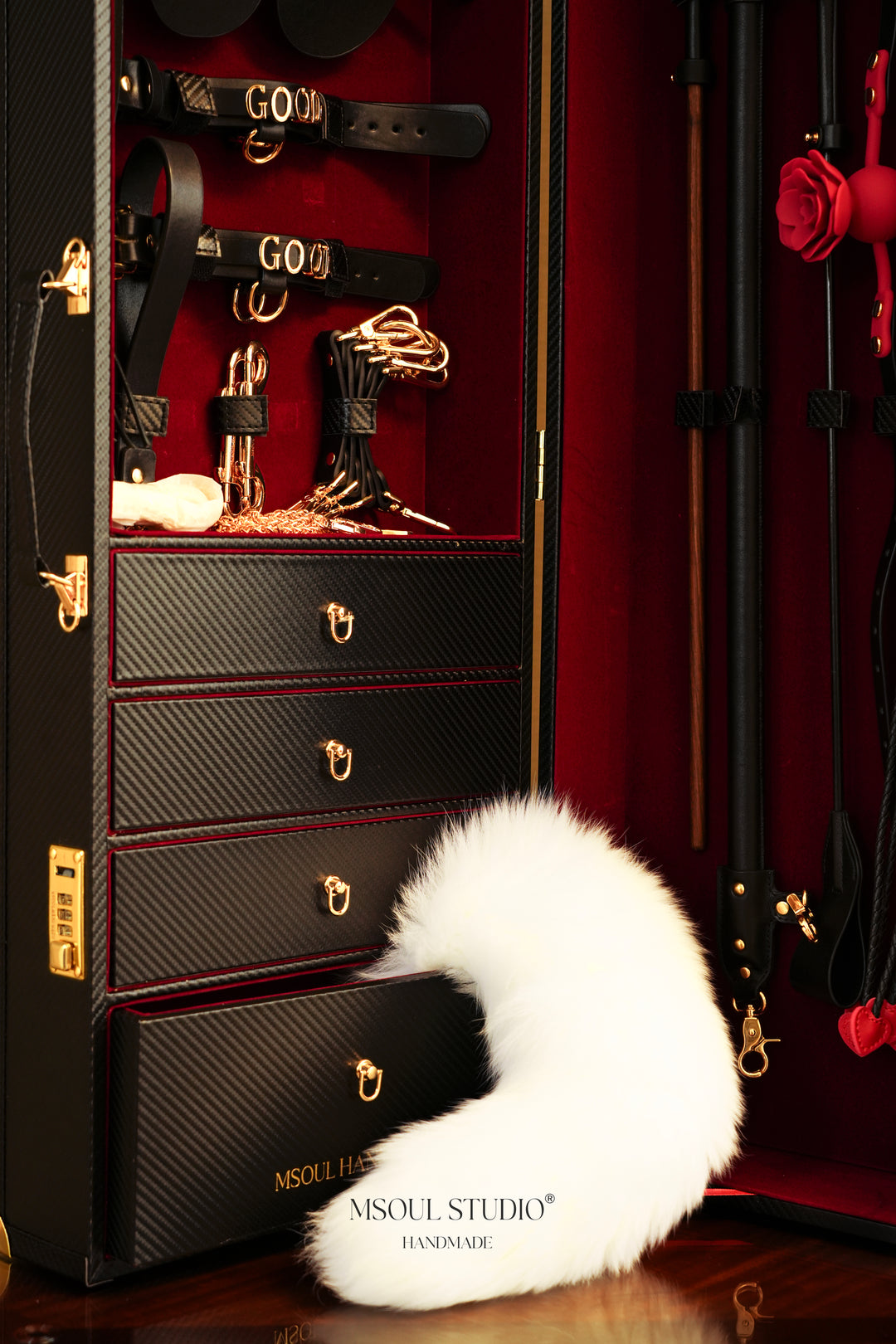 Gold-letter leather cuffs, gold chains and drawers inside the black trunk