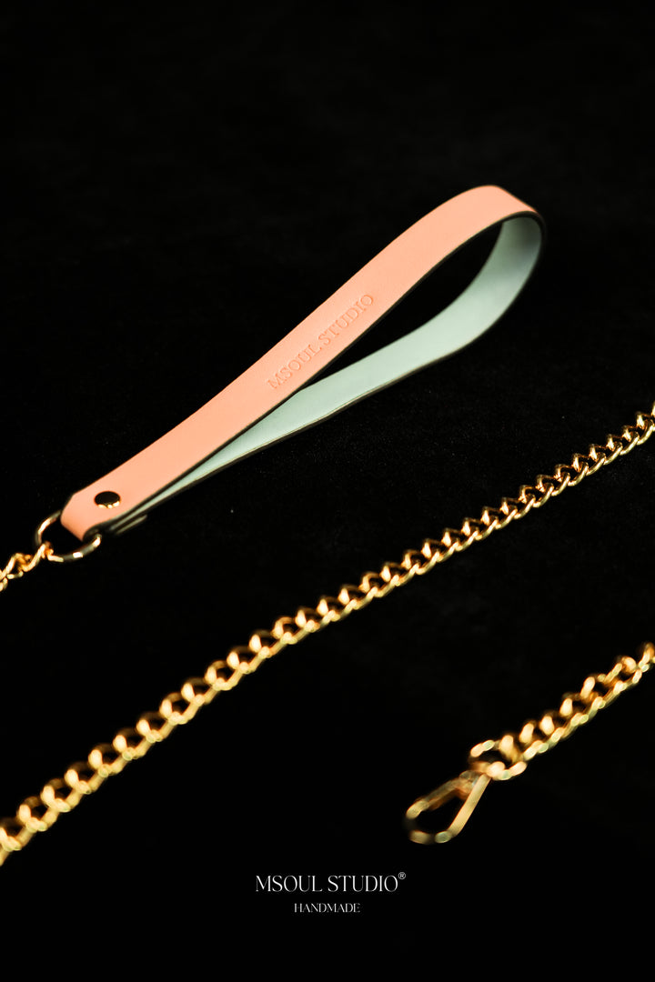 Close-up of the debossed vegan leather handle, gold ring and chain links