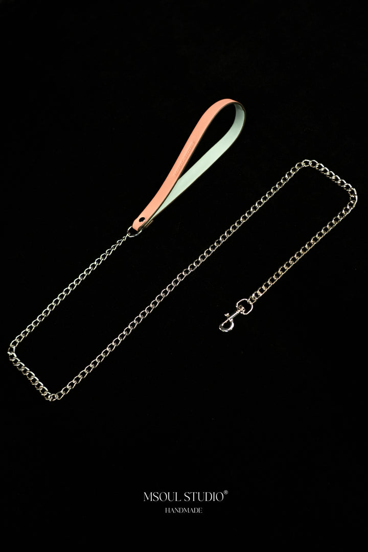 Pink vegan leather handle and silver-tone chain laid diagonally