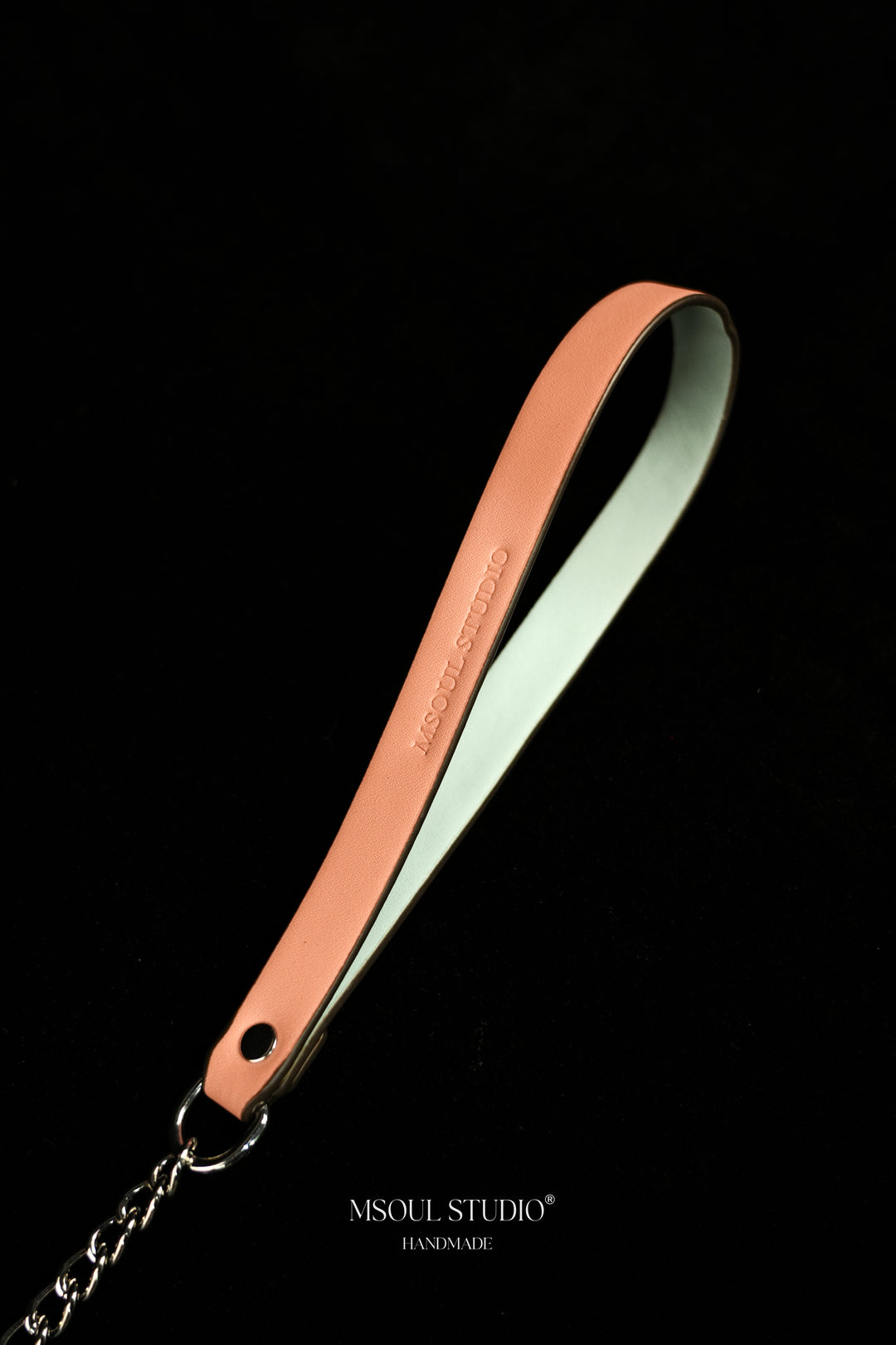 Close-up of the pink vegan leather handle with debossed logo and silver-tone ring