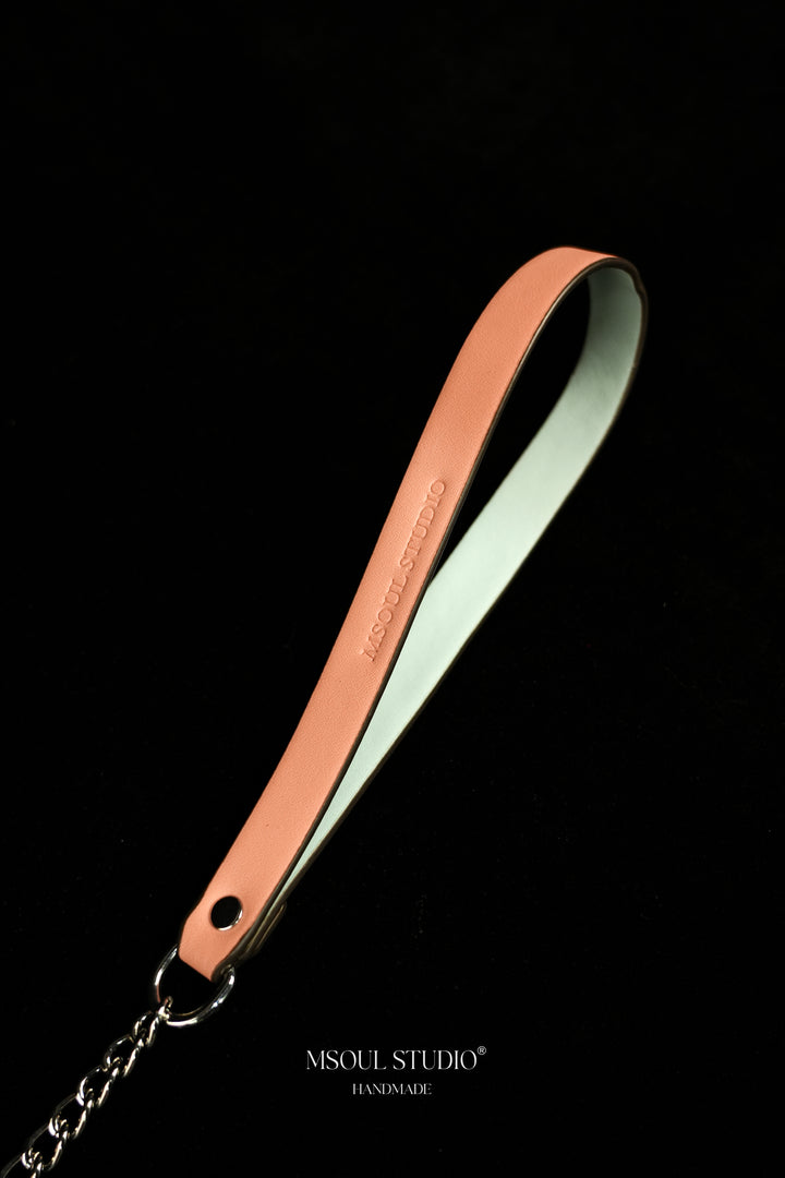 Close-up of the pink vegan leather handle with debossed logo and silver-tone ring